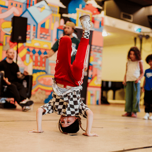 Kind is aan het breakdancen tijdens het Hillevliet Festival.